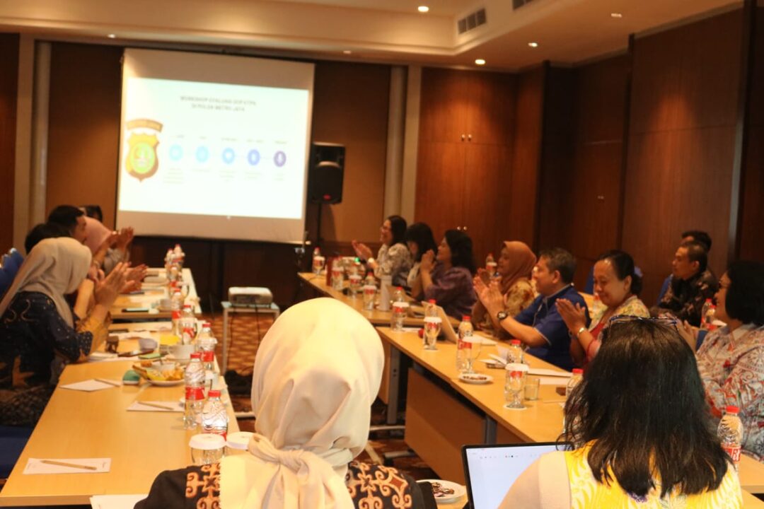 Group of people around conference tables watching a presentation