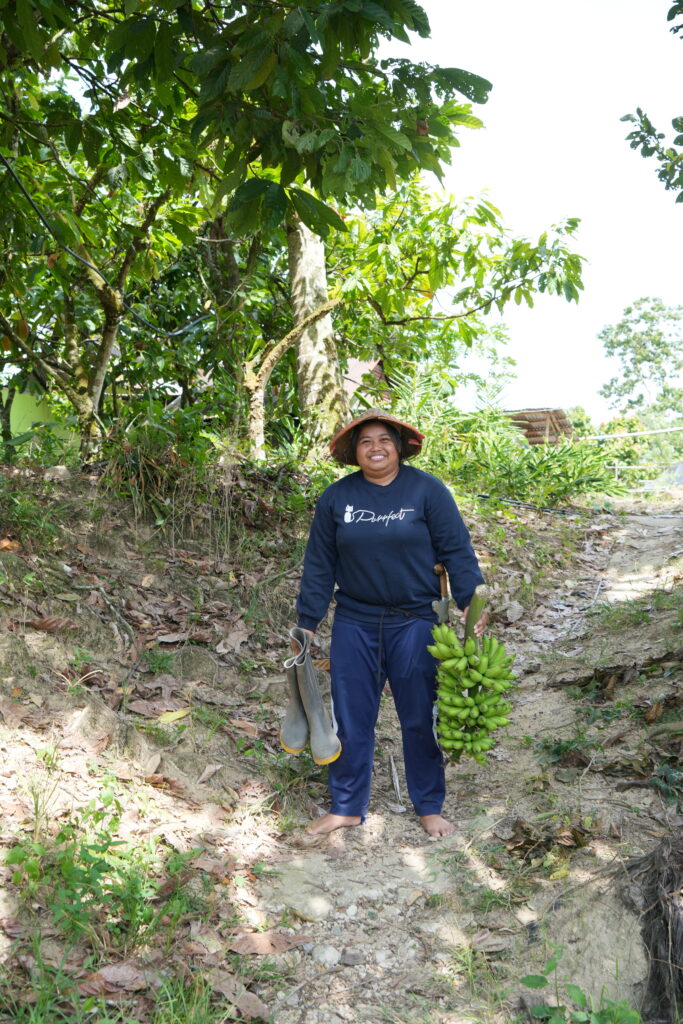 A woman smiles while holding work boots.