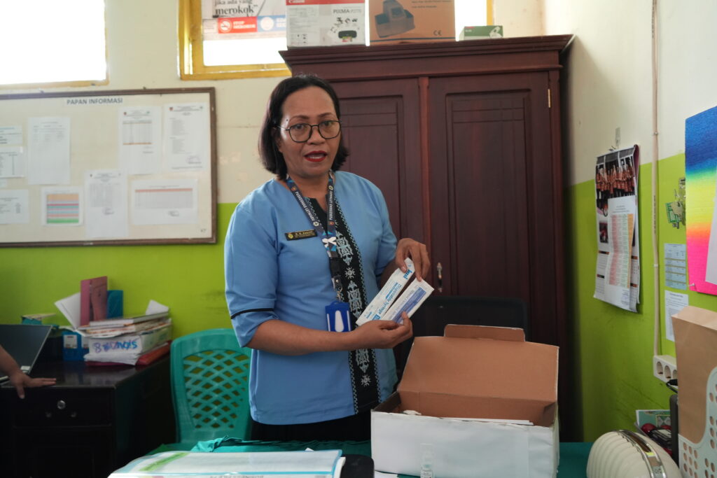 Seorang wanita memperlihatkan perlengkapan kesehatan.