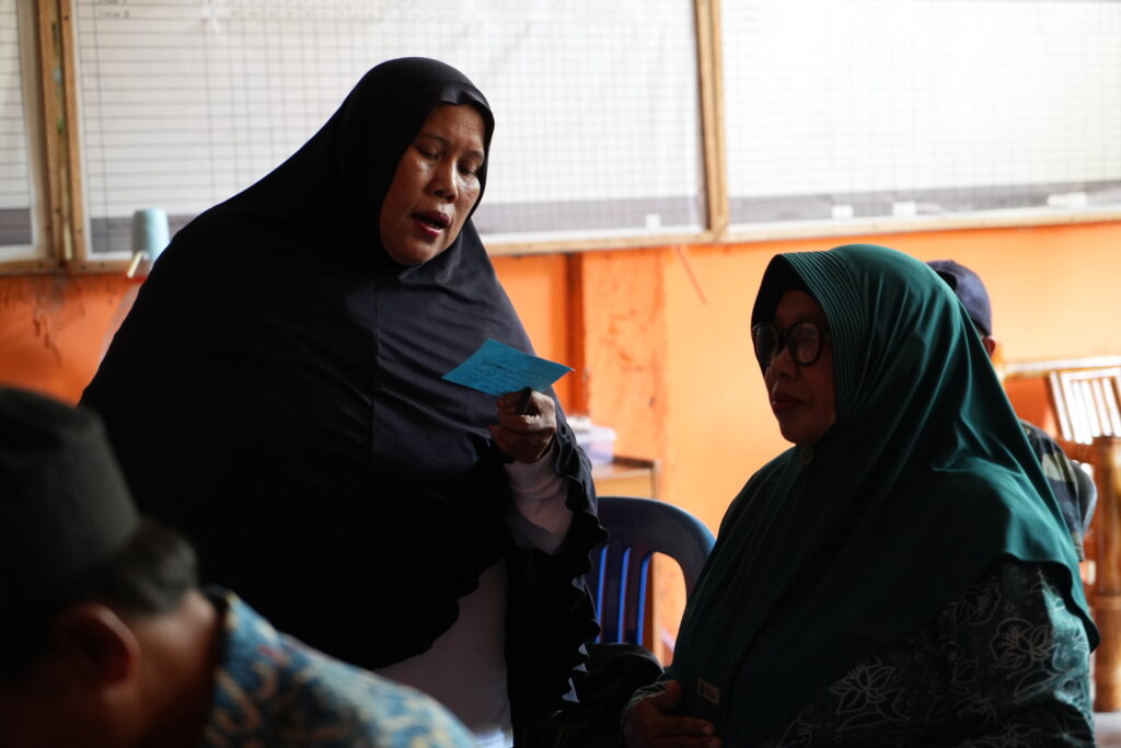 Seorang wanita sedang membaca dari sebuah catatan.