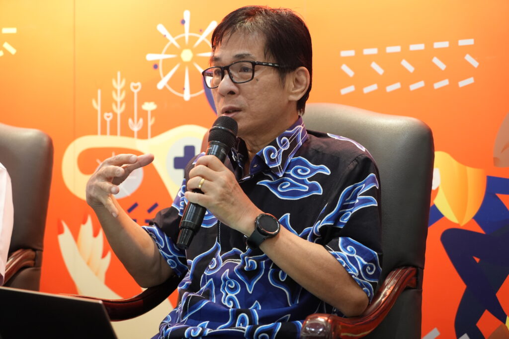 Seorang pria berbicara ke mikrofon.