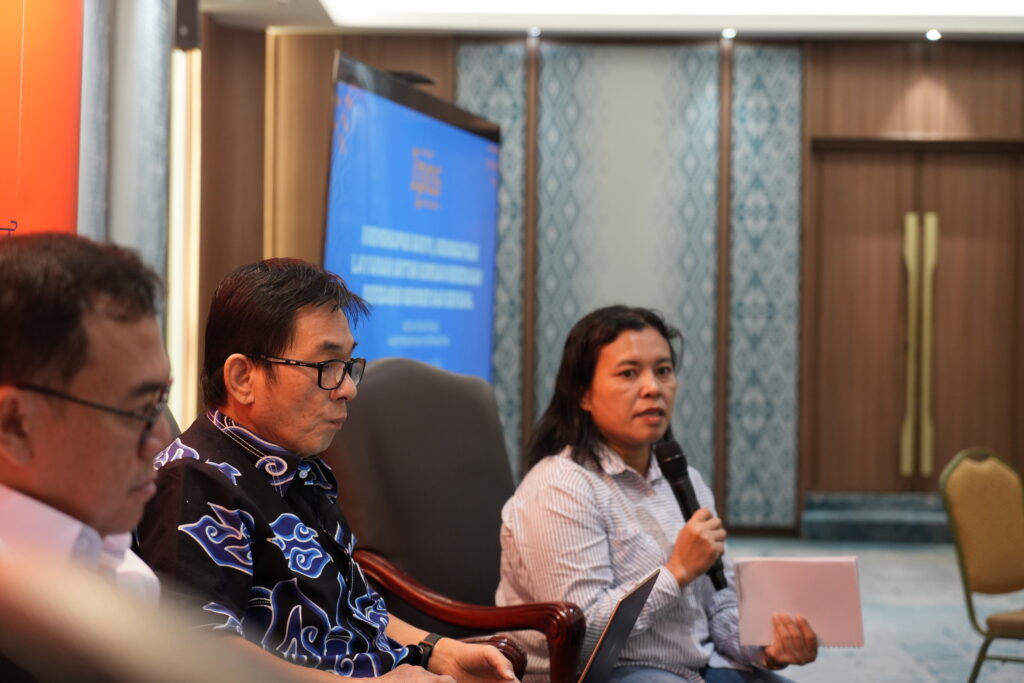 Seorang wanita di panel sedang berbicara ke mikrofon.