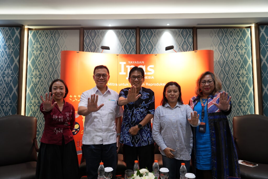 Lima orang berdiri dengan tangan terulur.