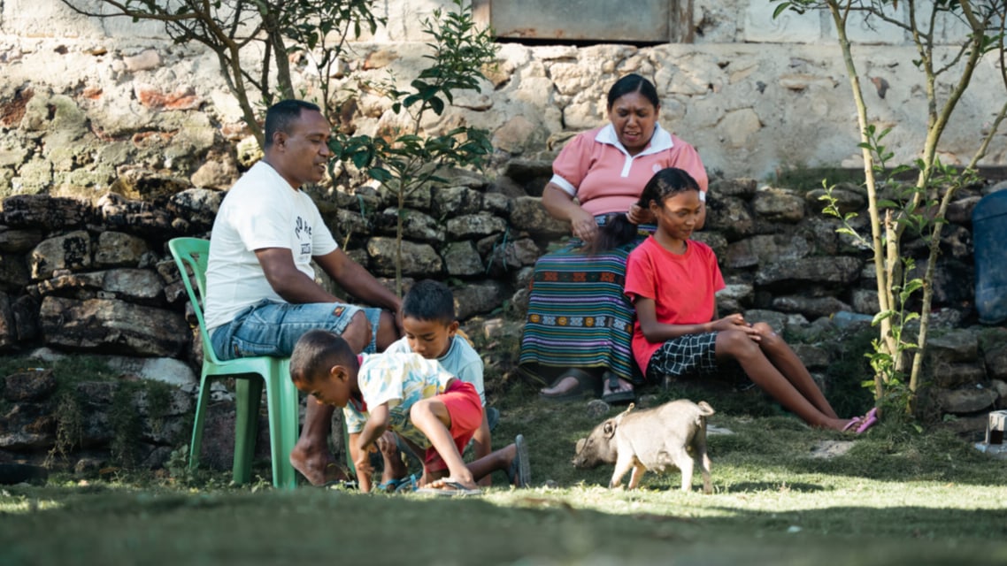 A family sitting outside their home.
