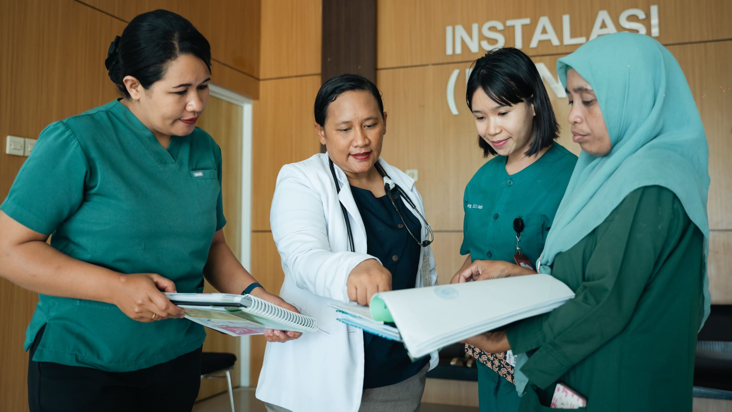 dr.-Herwinda-Gerladus-berdiskusi-membaca-dokumen-rekam-medis-bersama-tiga-perawat-di-instalasi-RSUD-Naibonat-di-Kabupaten-Kupang A doctor and nurses